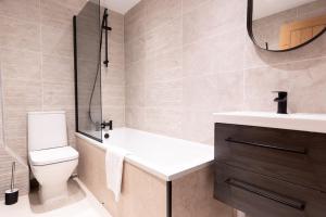 a bathroom with a tub and a toilet and a sink at FORD GATE - Modern Luxury Cottage based in Holmfirth in Holmfirth +26 photos