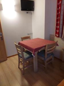 a table with two chairs and a red table cloth at Agritur Masi Brenta in Rovereto