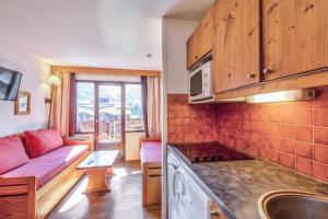 a kitchen and a living room with a couch at Résidence Quartier Falaise - maeva Home - Studio 4 Personnes - Confort 69 in Avoriaz