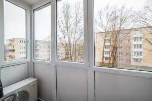 Habitación con 3 ventanas con vistas a un edificio en Frida Elite Apartments en Šiauliai