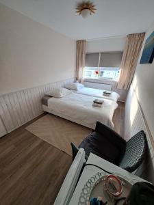 ein kleines Hotelzimmer mit einem Bett und einem Tisch in der Unterkunft AgterdeKoog in De Koog