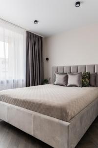 a large bed in a bedroom with a large bed sidx sidx sidx at Frida Elite Apartments in Šiauliai