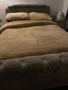 Una cama marrón con dos almohadas encima. en Holmhurst, en South Bank
