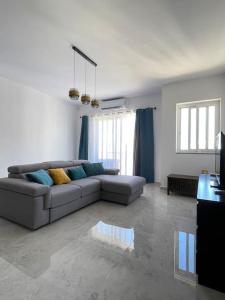 un soggiorno con divano e tavolo di Apartment, Few Steps from Ghadira Bay a Mellieħa