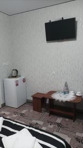 a room with a table and a television on a wall at Готель Ассоль in Khmelnytskyi