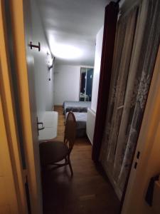 - un couloir avec une chambre dotée d'un lit et d'une chaise dans l'établissement Hotel de Nantes, à Paris