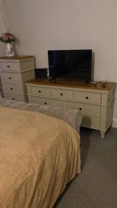 Un dormitorio con un tocador con TV. en Holmhurst, en South Bank