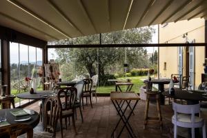 a restaurant with tables and chairs and a large window at Locanda De Banchieri in Fosdinovo