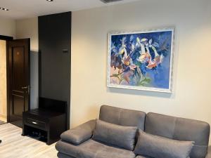 a living room with a couch and a painting on the wall at Dreams Hotel in Gjirokastër
