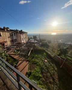 un antiguo edificio en una colina con la puesta de sol en el fondo en Casa vacanze panoramico Versilia, en Capriglia