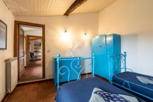 1 dormitorio con cama azul y espejo en Casa vacanze panoramico Versilia, en Capriglia