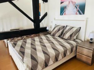 1 cama con edredón blanco y negro a cuadros en una habitación en Studio de 42m2, vue imprenable, en Tournon-sur-Rhône