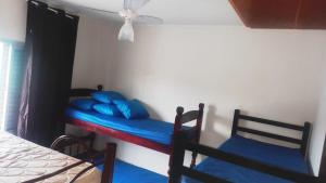 a bedroom with two bunk beds with blue pillows at Apartamento Praia Mongagua in Mongaguá