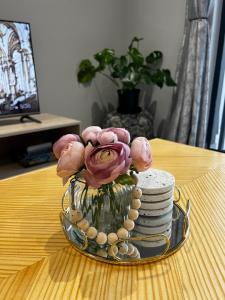 um vaso cheio de flores cor-de-rosa sobre uma mesa em Affordable Luxury Apartment em Gqeberha