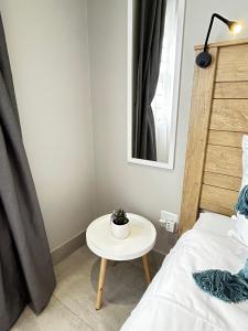 uma pequena mesa branca num quarto com uma cama em Affordable Luxury Apartment em Gqeberha