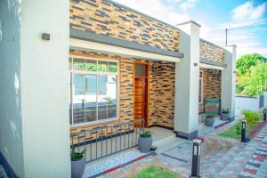 una casa con un muro di mattoni e una finestra di Nellly's Rest House a Dar es Salaam