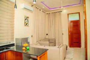 un soggiorno con divano e tavolo di Nellly's Rest House a Dar es Salaam
