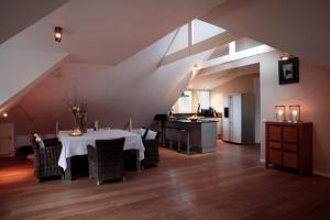 una sala da pranzo con tavolo e una cucina di Loft aan Zee, Penthouse B&B aan de Schoorlse duinen a Schoorl