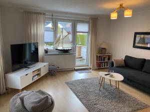 a living room with a couch and a tv at Ankerplatz 2 in Zingst