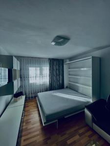 Un dormitorio pequeño con una cama y una ventana. en Apartament ASK HOME, en Slănic-Moldova