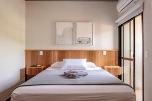 1 dormitorio con 1 cama y 2 cuadros en la pared en JQY Beach Flats - Piscina - Carregador de veículos elétricos e híbridos - Garagem Subterrânea - Ar condicionado - WI-FI en Juquei