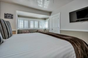 a bedroom with a large white bed and a flat screen tv at Craftsman Inn in Calistoga