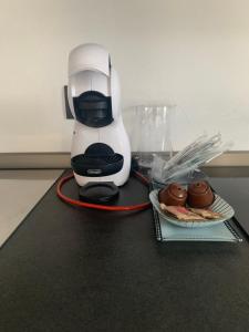 a coffee maker and a plate of donuts on a counter at Oasi verde in Aosta +7 photos