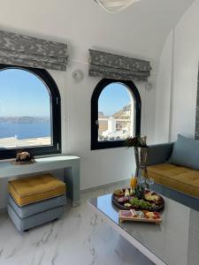 a living room with two windows and a tray of fruit on a table at Avant Garde Firostefani in Firostefani