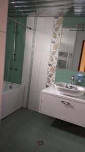uma casa de banho com um lavatório, uma banheira e um espelho. em Villa 3 chambre em Yerevan
