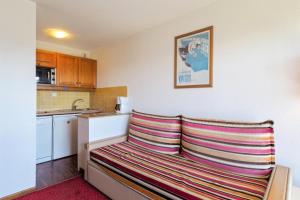 a kitchen with a bench in the corner of a room at Résidence Le Pédrou - maeva Home - Studio 2 Personnes - Confort MAE-3956 in Font Romeu Odeillo Via