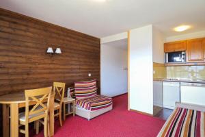 a kitchen with a table and chairs in a room at Résidence Le Pédrou - maeva Home - Studio 2 Personnes - Confort MAE-3956 in Font Romeu Odeillo Via