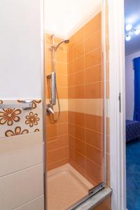 um chuveiro na casa de banho com azulejos laranja em ARIA DI MARE ROOMS em Cefalù
