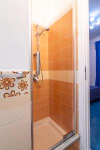 a shower in a bathroom with orange tiles at ARIA DI MARE ROOMS in Cefalù