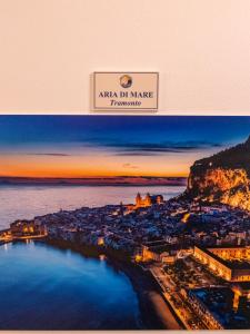 a poster of a city with a view of the water at ARIA DI MARE ROOMS in Cefalù