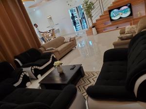a living room with couches and a couch and a tv at Luxe villa ciné concorde in Agbato