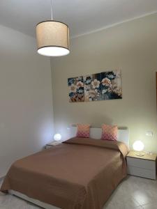 Un dormitorio con una cama y un cuadro en la pared. en La casa di Paloma, en La Spezia
