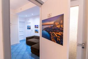 uma sala de estar com um quadro na parede em ARIA DI MARE ROOMS em Cefalù