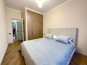 um quarto com uma cama grande e almofadas azuis em Апартаменты в ЖК "AURUS" em Almaty