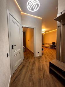 um corredor com uma porta e uma sala de estar em Апартаменты в ЖК "AURUS" em Almaty