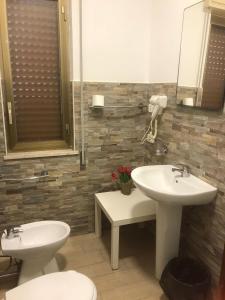 uma casa de banho com 2 lavatórios, um WC e um espelho. em La Dimora dei sette Arcangeli em Palermo