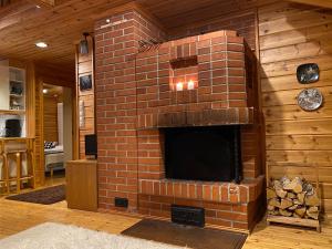 einen gemauerten Kamin mit einem TV in einem Zimmer in der Unterkunft Alppiruusu B in Syöte