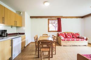 a kitchen and living room with a table and a couch at Résidence Les Gentianes - maeva Home - Appartement 3 Pièces 6 Personnes - C 38 in Puy-Saint-Vincent