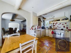 une cuisine avec une table en bois et une salle à manger dans l'établissement Maison la Garrigue en Provence, à Maillane