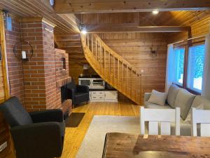 ein Wohnzimmer mit einer Treppe und einer Ziegelwand in der Unterkunft Alppiruusu B in Syöte + 8 Fotos