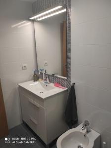 La salle de bains est pourvue d'un lavabo et d'un miroir. dans l'établissement Apartamento nuevo en playa de Piles. Costa Blanca, à Piles