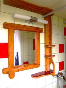 a bathroom mirror with a wooden frame on a wall at Gästehaus am Wangeliner Garten in Wangelin