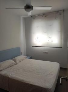 - une chambre avec un lit et une projection sur le mur dans l'établissement Apartamento nuevo en playa de Piles. Costa Blanca, à Piles