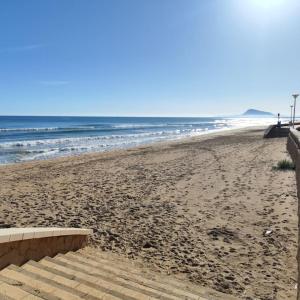une plage de sable avec des escaliers menant à l'océan dans l'établissement Apartamento nuevo en playa de Piles. Costa Blanca, à Piles