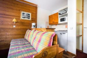 a kitchen with a bench with a blanket on it at Les Résidences de Valmorel - maeva Home - 2 Pièces 5 Personnes Confort 51 in Valmorel