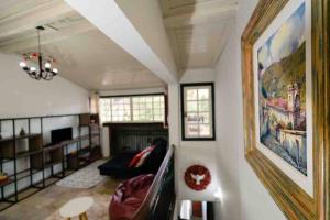 a living room with a couch and a painting on the wall at Casadinha - Casa no centro histórico de Ouro Preto in Ouro Preto